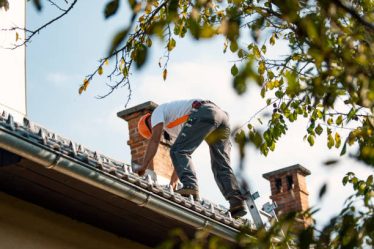Un couvreur travaille sur la toiture d’un bâtiment. Il installe, répare et entretient les toits. Cependant, les panneaux solaires exigent