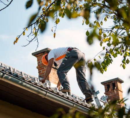 Un couvreur travaille sur la toiture d’un bâtiment. Il installe, répare et entretient les toits. Cependant, les panneaux solaires exigent